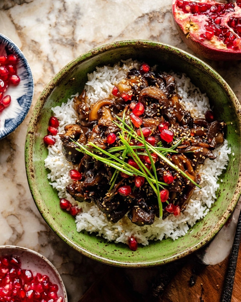 A green bowl filled with a base layer of fluffy white rice that is topped with dark brown, glossy cooked mushrooms mixed with a sauce. Scattered red pomegranate seeds add bright pops of color, and the dish is finished with a sprinkle of light brown sesame seeds and thin green scallion strips placed on top. The bowl sits on a wooden surface, with a halved pomegranate and a small bowl with loose pomegranate seeds nearby. photo taken with an iphone --ar 4:5 --v 7