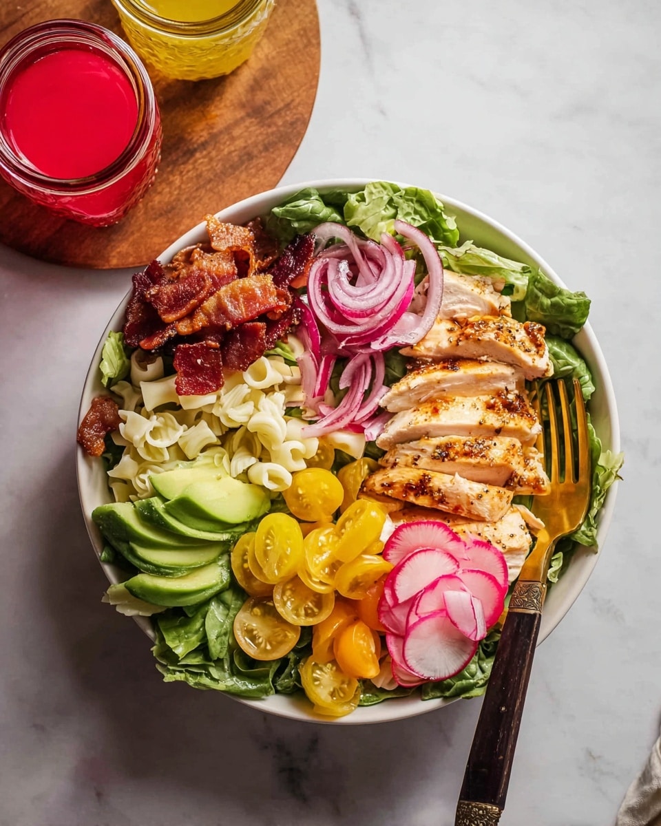 A white bowl filled with a colorful salad is placed on a white marbled surface. The salad has six main layers arranged side by side on a bed of dark green leafy greens: crispy brown bacon pieces on the top left, curly white pasta next to it, thinly sliced red onions below the pasta, fanned slices of bright green avocado at the bottom left, thin ribbons of pale green cucumber on the top right, and sliced yellow tomatoes with a few smaller red tomato halves near the center. On the right side, grilled chicken breast slices with a light golden-brown sear lay over greens, showing the juicy white inside. Thinly sliced pink radishes are positioned near the chicken on the far right. A gold fork with a dark handle rests on the edge of the bowl. Nearby, a small clear glass with bright red liquid and a small jar with yellow liquid are placed on a round wooden board just off to the top left. Photo taken with an iphone --ar 4:5 --v 7