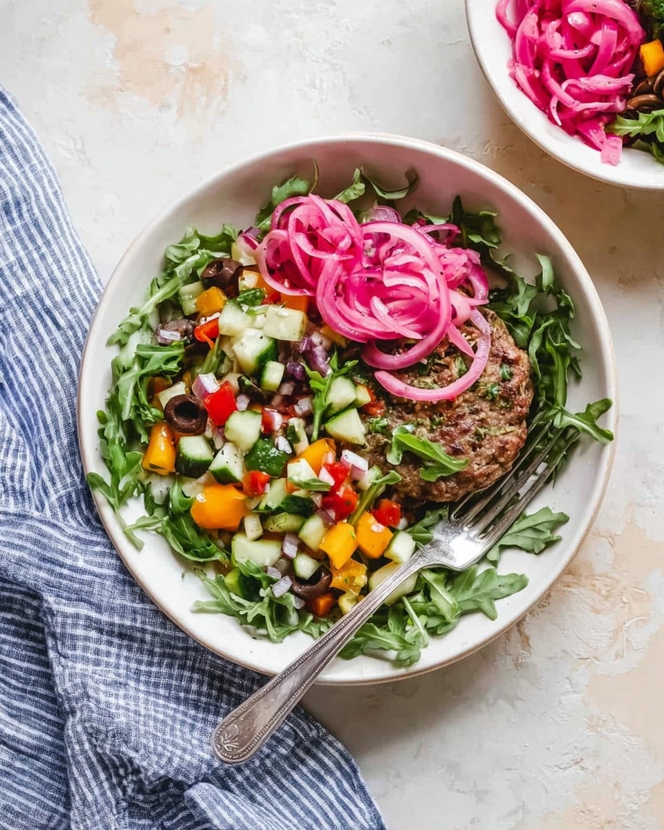 A white bowl holds a fresh salad with several visible layers: at the bottom is a layer of green arugula leaves, topped with a variety of diced vegetables including small pieces of green cucumber, yellow bell pepper, red bell pepper, and black olives; on top of these vegetables is a cooked brown patty or round piece of food partially visible on the right side; covering part of the patty and salad are thin slices of bright pink pickled onions arranged in spirals. A silver fork rests inside the bowl on the right side. The bowl is placed on a white marbled surface with a blue and white striped cloth partially visible nearby, and a second white bowl with more pickled onions is in the upper right corner. photo taken with an iphone --ar 4:5 --v 7