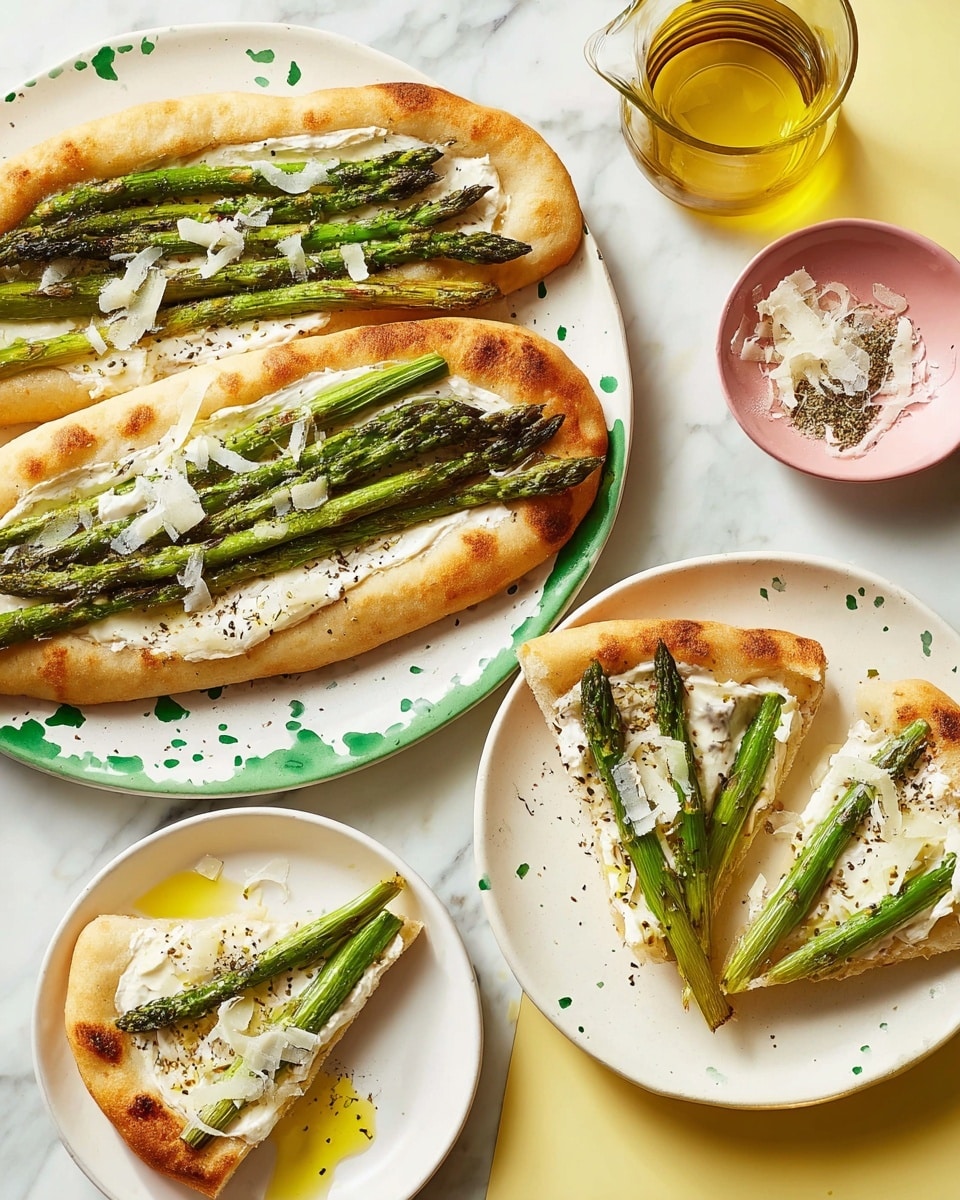 The dish shows two oval-shaped flatbreads on a white plate with green spots, each topped with a layer of creamy white cheese spread, and arranged with several long, thin grilled green asparagus spears laid side by side. There are light golden brown lightly crispy edges on the flatbreads, and thin white cheese shavings scattered on top. Next to the main plate is a white plate holding two triangular flatbread slices with the same toppings of white cheese spread, three asparagus spears on each, and a drizzle of olive oil with some coarse black pepper. A small bowl with more white cheese shavings and a glass container with golden olive oil sit nearby on a white marbled surface. Photo taken with an iphone --ar 4:5 --v 7