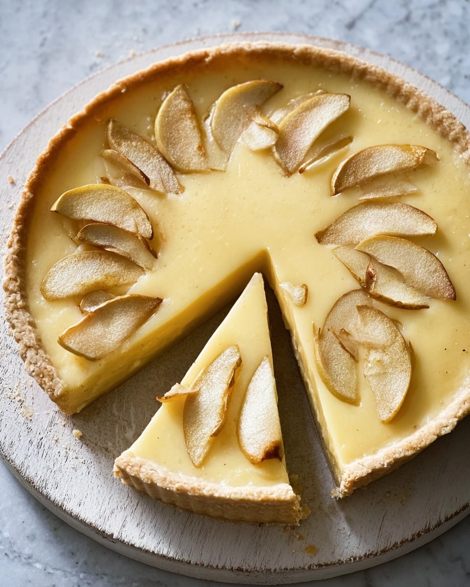A pie with a golden crust and smooth, pale yellow filling sits on a round white wooden board. The filling is decorated with lightly browned, small apple slices arranged in a circular pattern on top. Two slices of the pie are cut and slightly pulled away from the main pie, showing the smooth texture of the filling inside. The surface beneath the board is a white marbled texture. Photo taken with an iphone --ar 4:5 --v 7