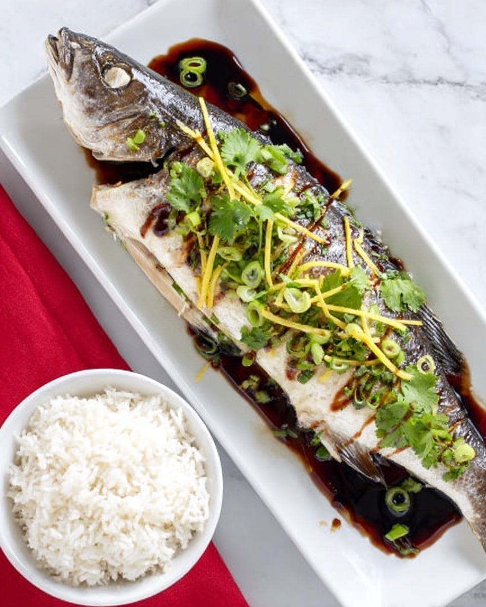 A whole cooked fish with light silver skin lies on the right side of a white rectangular plate, topped with thin green strips (possibly scallions) and fresh green cilantro leaves. Dark brown sauce is drizzled over the fish in thin, irregular lines. Under the fish, there is a light golden sauce pooling on the plate. On the left side of the plate, there is a round white bowl filled with fluffy white rice. The plate is placed on a white marbled surface with a red cloth peeking out on the left side. Photo taken with an iphone --ar 4:5 --v 7