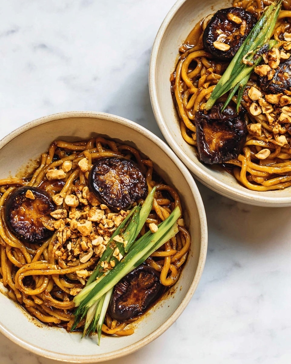 Two white bowls filled with thick, glossy brown noodles at the bottom layer, coated in sauce. On top of the noodles, there are dark brown, slightly crispy mushroom slices arranged mostly on one side. Scattered crushed light brown peanuts rest over the noodles and mushrooms, adding texture. Thin green cucumber sticks are placed on the side of the bowls, adding a fresh color contrast. The bowls sit on a white marbled surface, showing a clean and bright setting. photo taken with an iphone --ar 4:5 --v 7