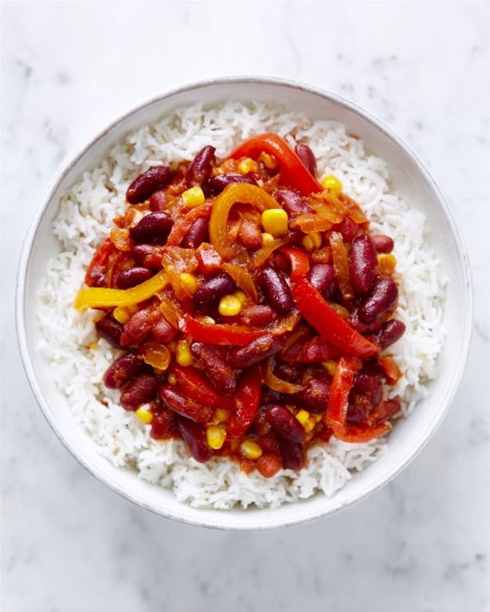 A white bowl filled with a base layer of fluffy white rice, topped with a colorful vegetable stew. The stew has pieces of red kidney beans, sliced red and yellow bell peppers, and corn in a rich, dark red sauce. The bowl is placed on a white marbled surface, creating a clean and bright background. photo taken with an iphone --ar 4:5 --v 7